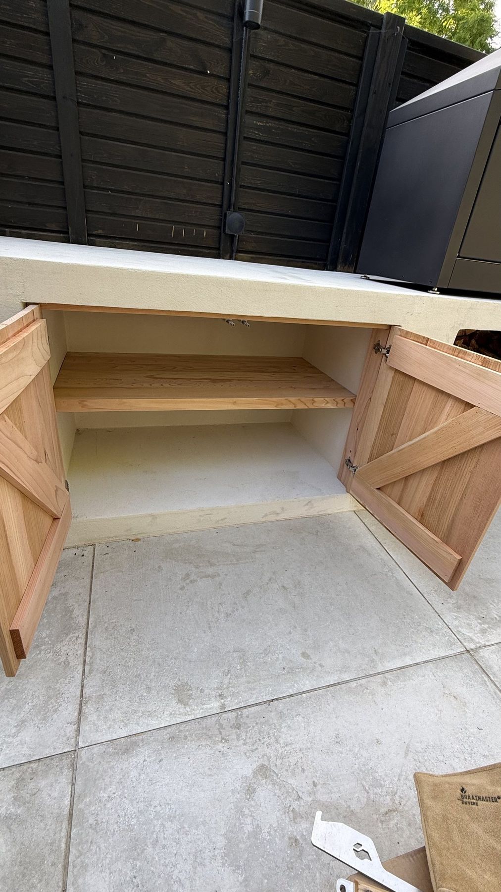 Close-up of hardwood cupboard doors set into the rendered kitchen base